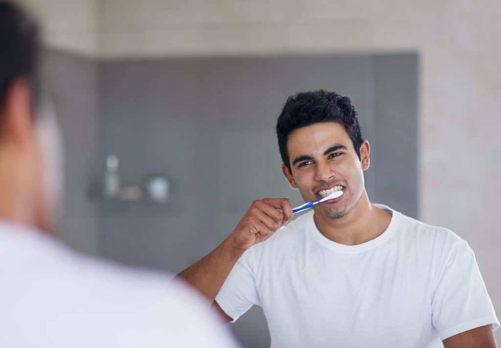 man brushing his teeth