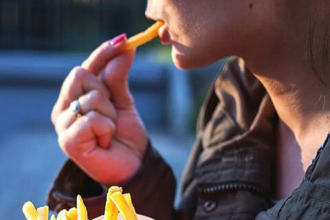 A women eating french fries
