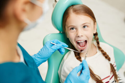 dentist operating on girl teeth
